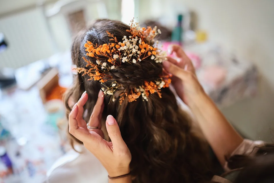 Flowers being placed in the bride’s hair
