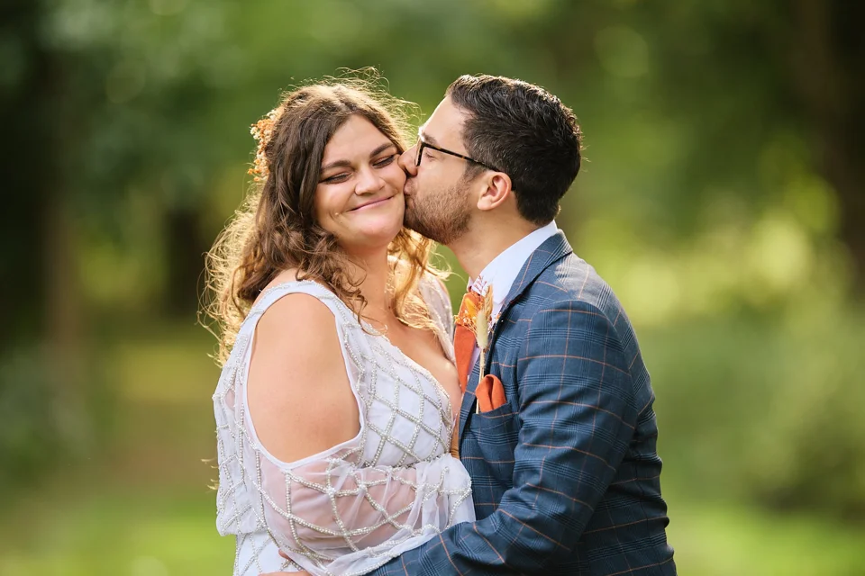 The groom kissing the bride’s cheek