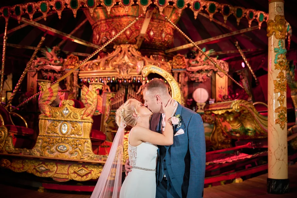 The couple together in front of the carousel