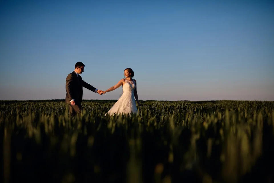 Steph and Kris holding hands in the evening light at Dairy Barns